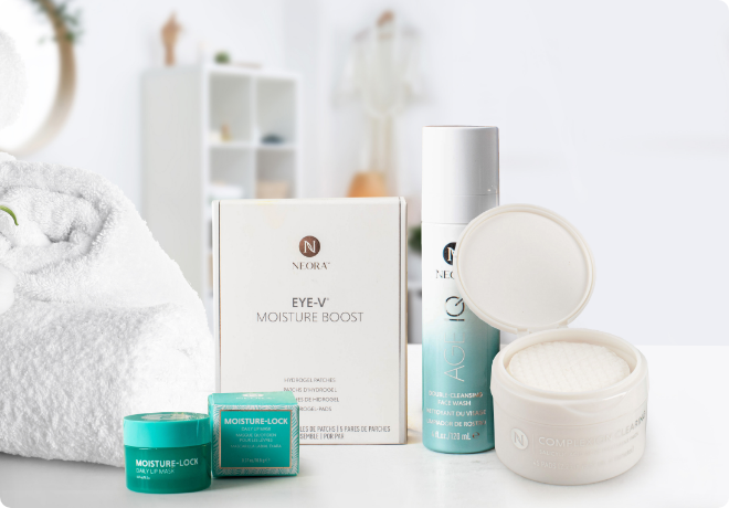 Neora’s Skincare Care Package, which includes Age IQ Double-Cleansing Face Wash, Complexion Clearing Treatment Pads, Eye-V Hydrogel Moisture Boost Patches and Moisture-Lock Lip Mask sitting on a bathroom counter.